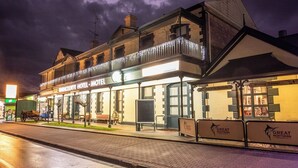 Un hotel con balcón, un cartel que anuncia una sala de juegos y un cartel para un club.