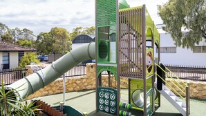 Un parque infantil con un tobogán, estructuras para escalar y un letrero que dice 'Find the Pairs'.