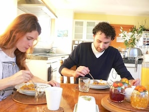 A dining table with plates of food, glasses, and a pitcher of juice. - Brook House Bed & Breakfast and Cottages (Kaikōura)
