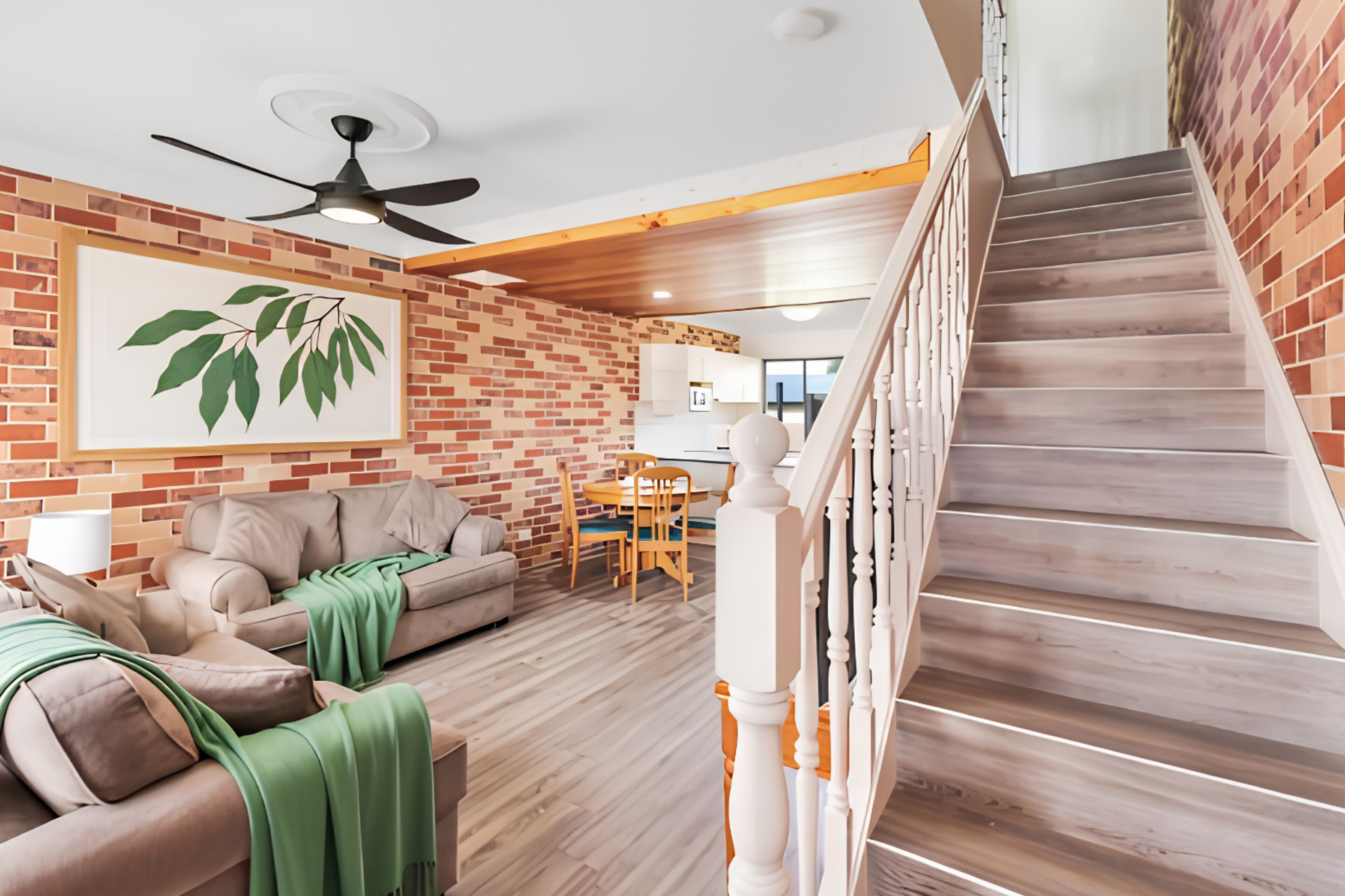 A living room with a sofa, a dining table, and a staircase with a wooden railing.