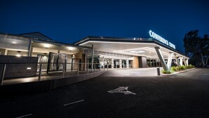 A modern building with a "CONFERENCE CENTER" sign, featuring a spacious entrance and a covered area with columns.