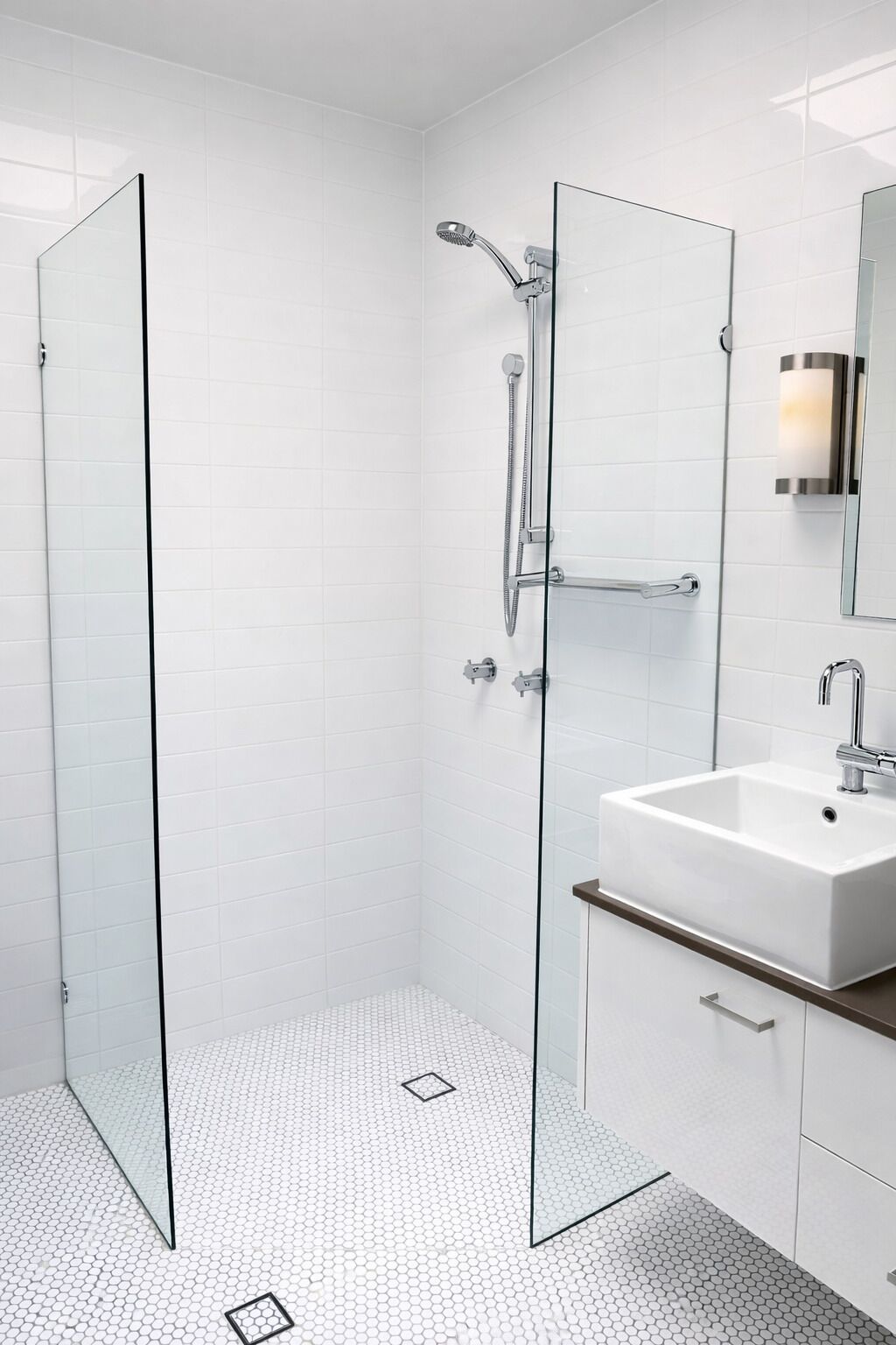 A modern bathroom with a glass shower enclosure, a white sink, and a mirror with a light.