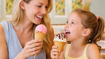 Una mujer y un niño en una mesa con helados.