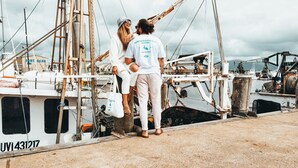 A couple standing on a boat dock with a marina in the background. - Harbourview House (Bermagui)