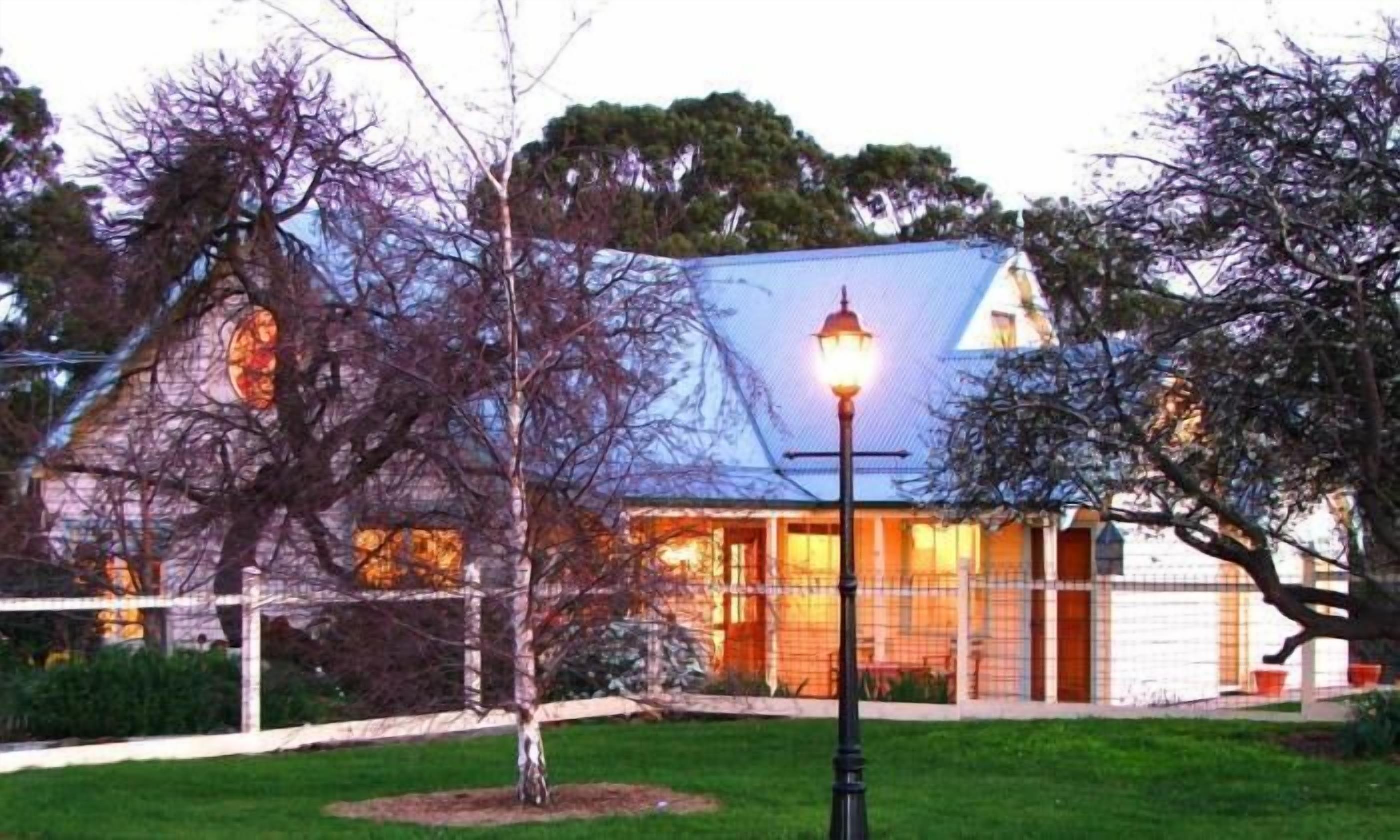 Un bâtiment avec un toit bleu, un lampadaire et une clôture.