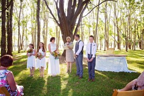 A wedding ceremony outdoors with guests seated on the grass. - Moruya Motel (Moruya)