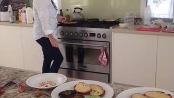 Una cocina con estufa, horno y varios alimentos sobre la encimera.