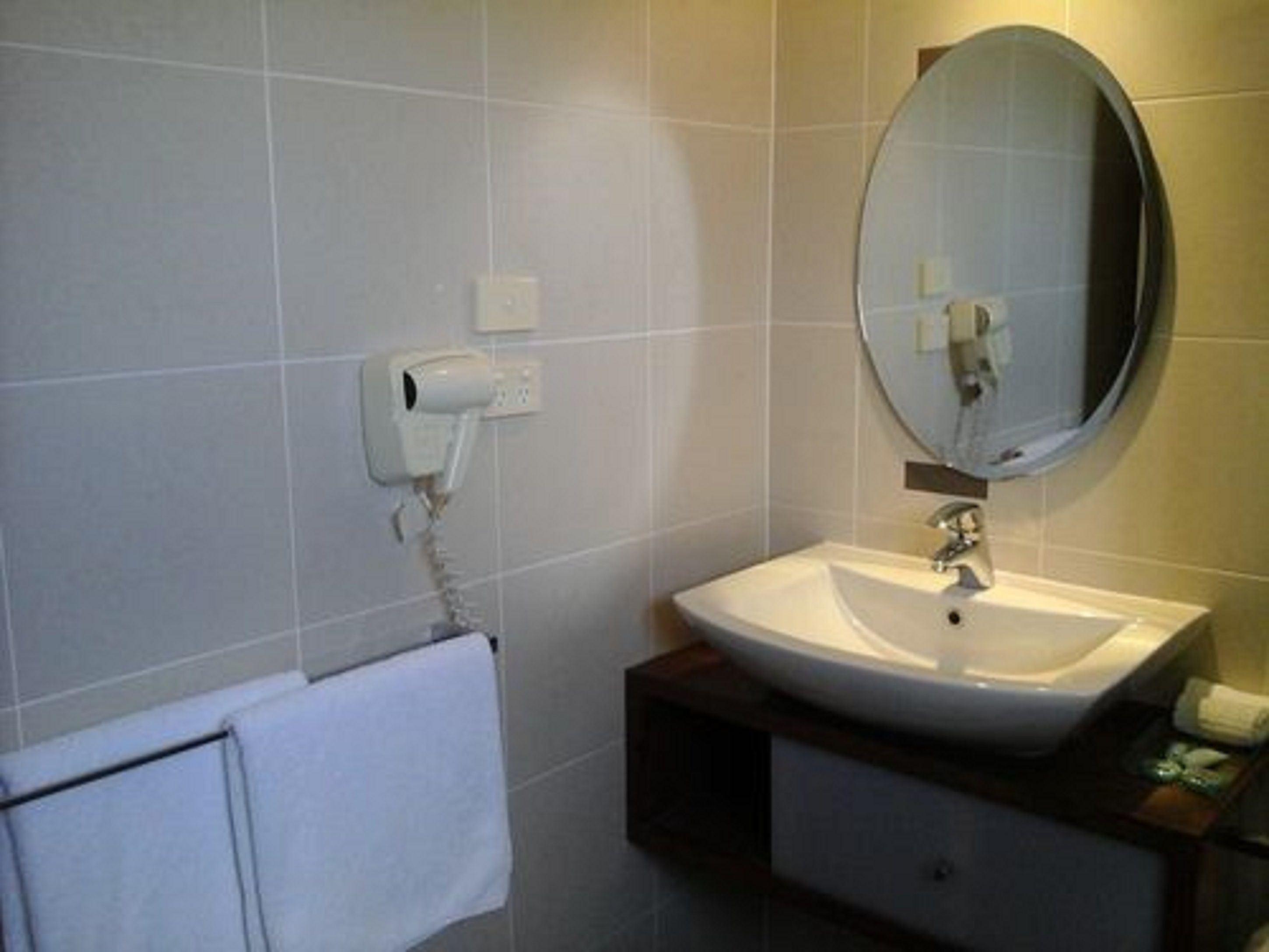 Ein Badezimmer mit Waschbecken, Spiegel und Handtuchhalter.