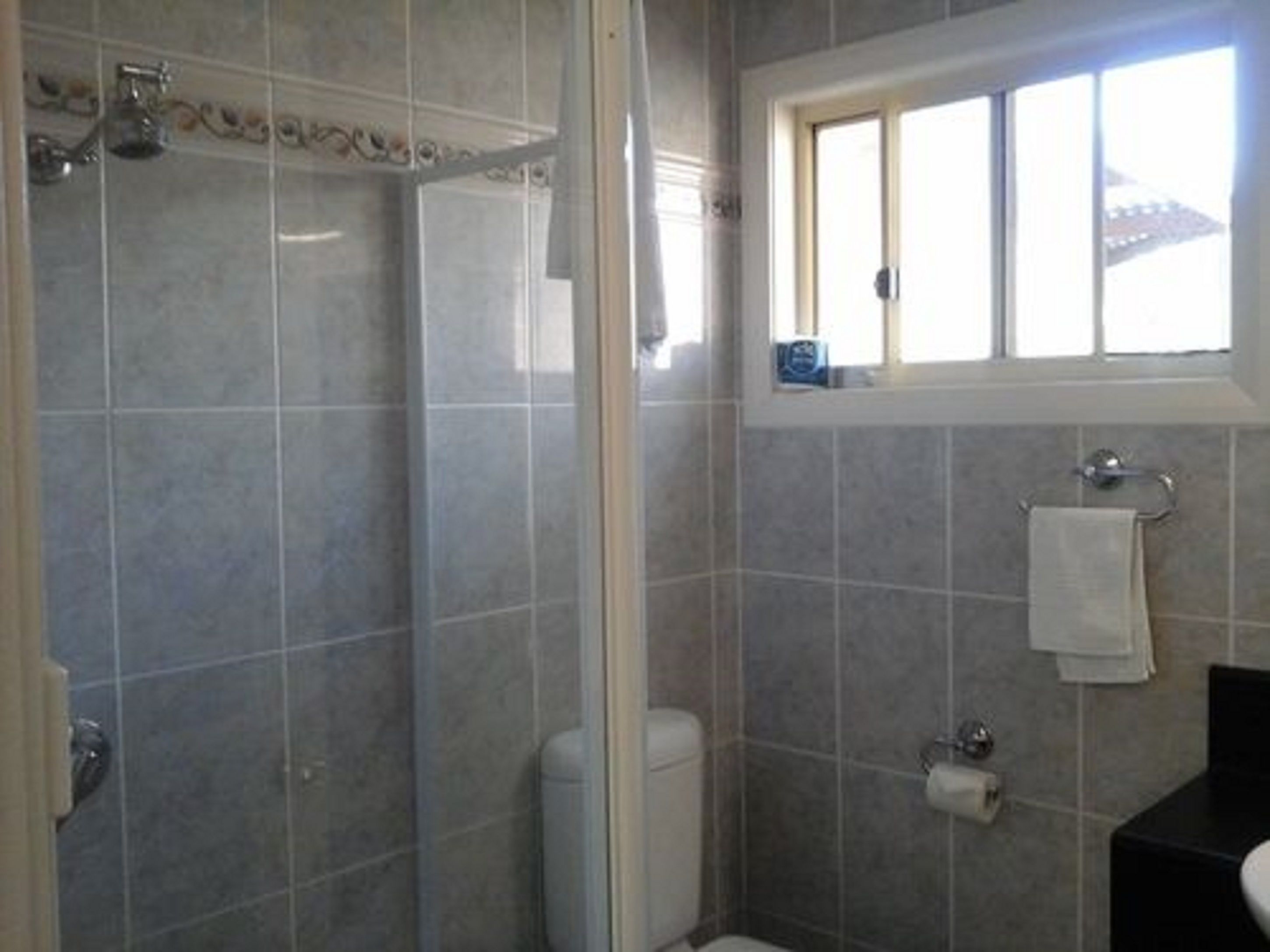 A bathroom with a shower, toilet, and sink.