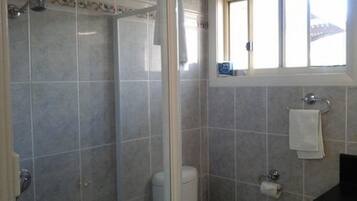 A bathroom with a shower, toilet, and sink.