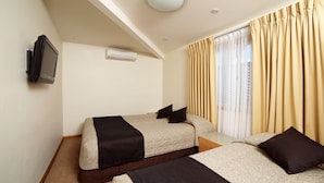 A hotel room with two beds, a television mounted on the wall, and a window with curtains. - Willows Motel Goulburn (Goulburn)