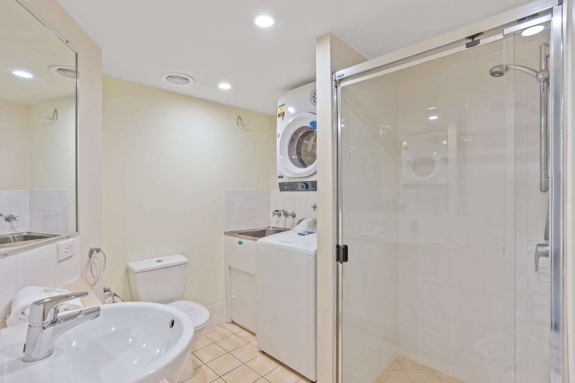 A modern bathroom with a sink, toilet, and a glass-enclosed shower.