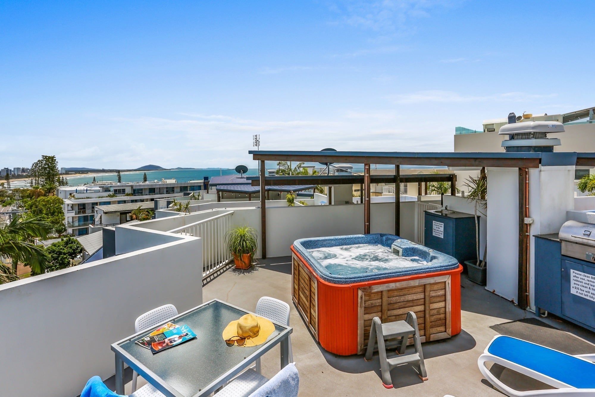 Une terrasse sur le toit avec un jacuzzi, des sièges extérieurs et une vue sur l’océan.
