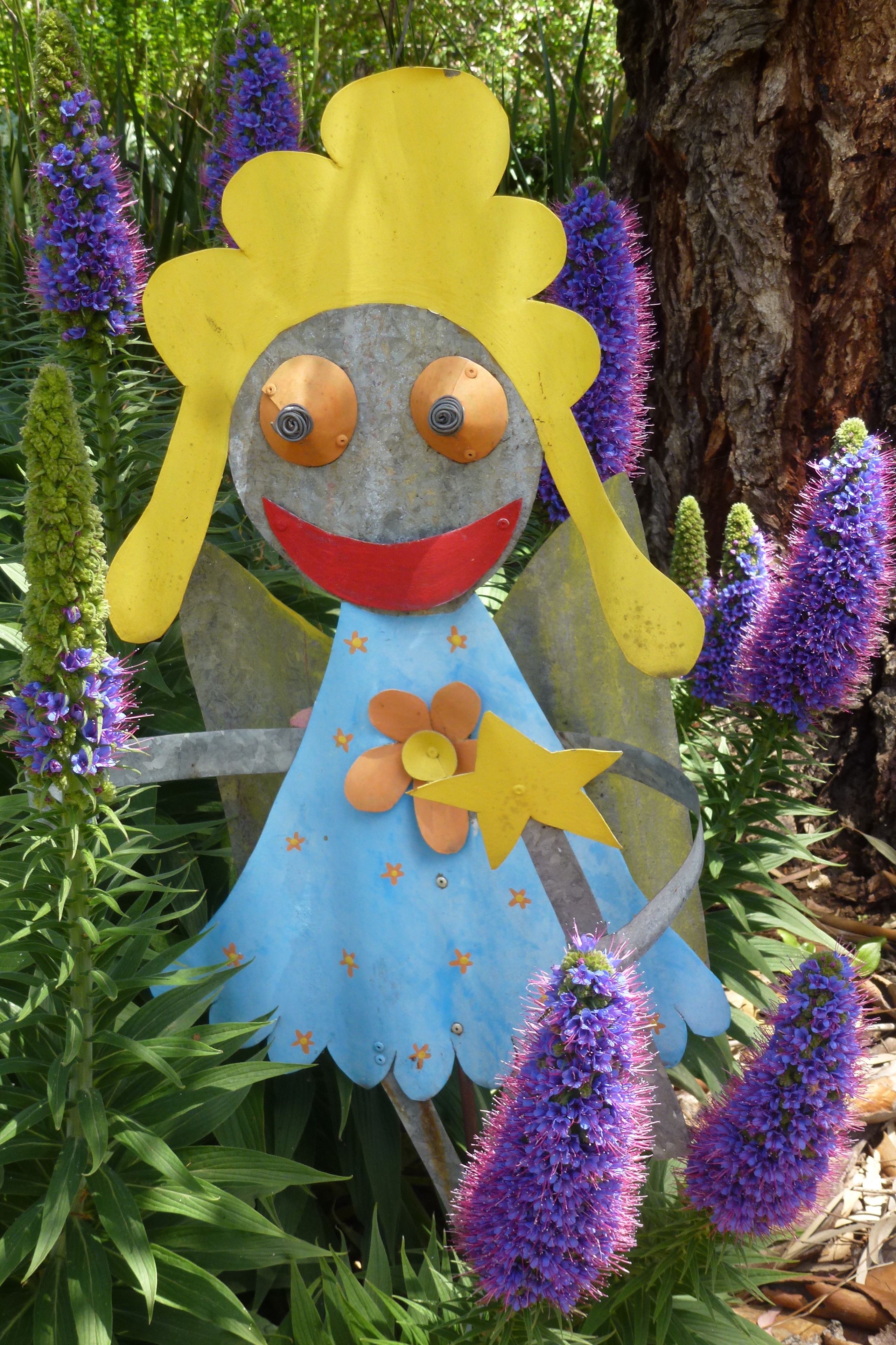 A decorative figure with a blue dress and yellow hair, surrounded by purple flowers.