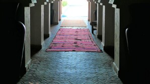 A corridor with a patterned carpet leading to a bright exit.