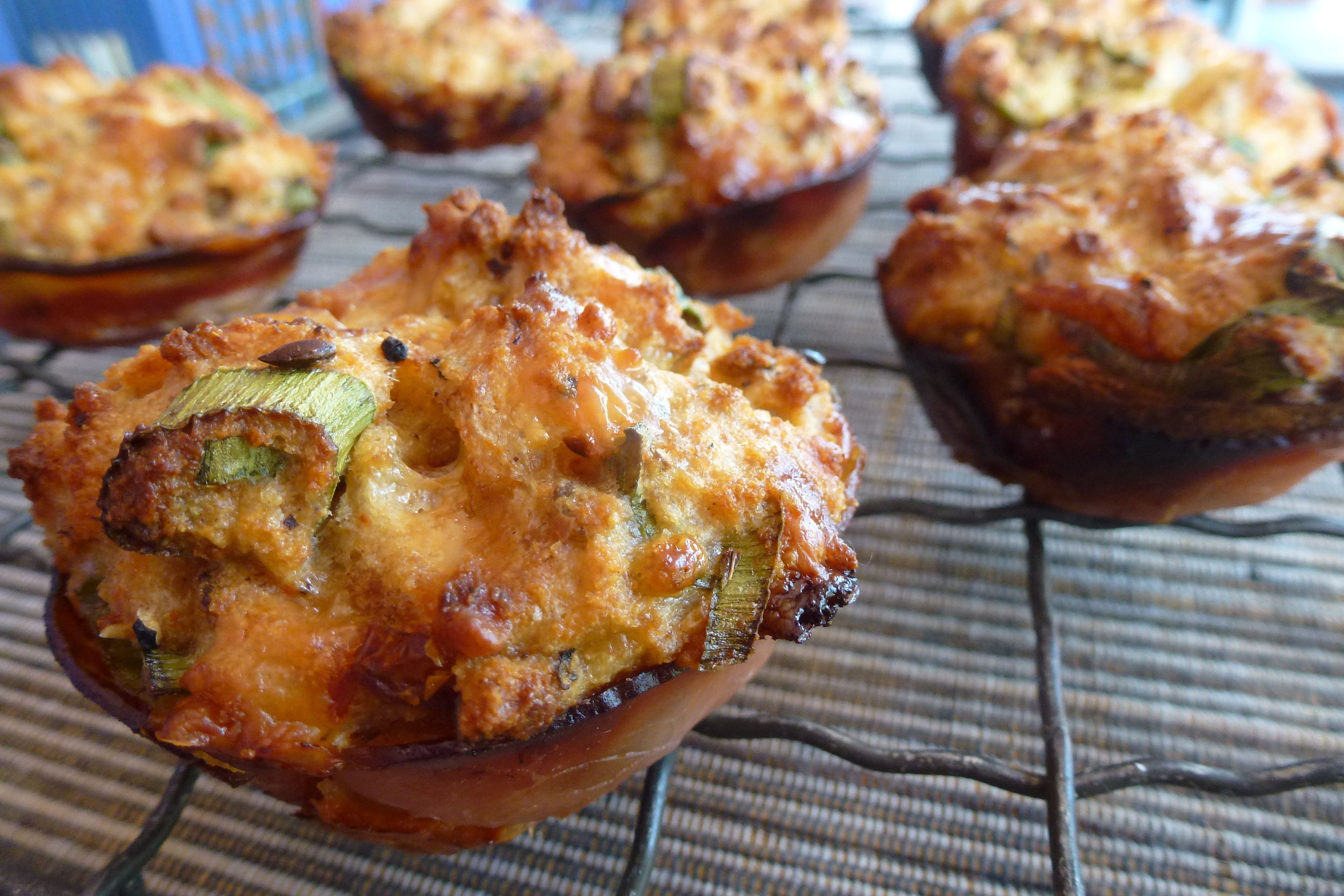 Un muffin con corteza dorada, posiblemente con vegetales y queso, sobre una rejilla enfriadora.