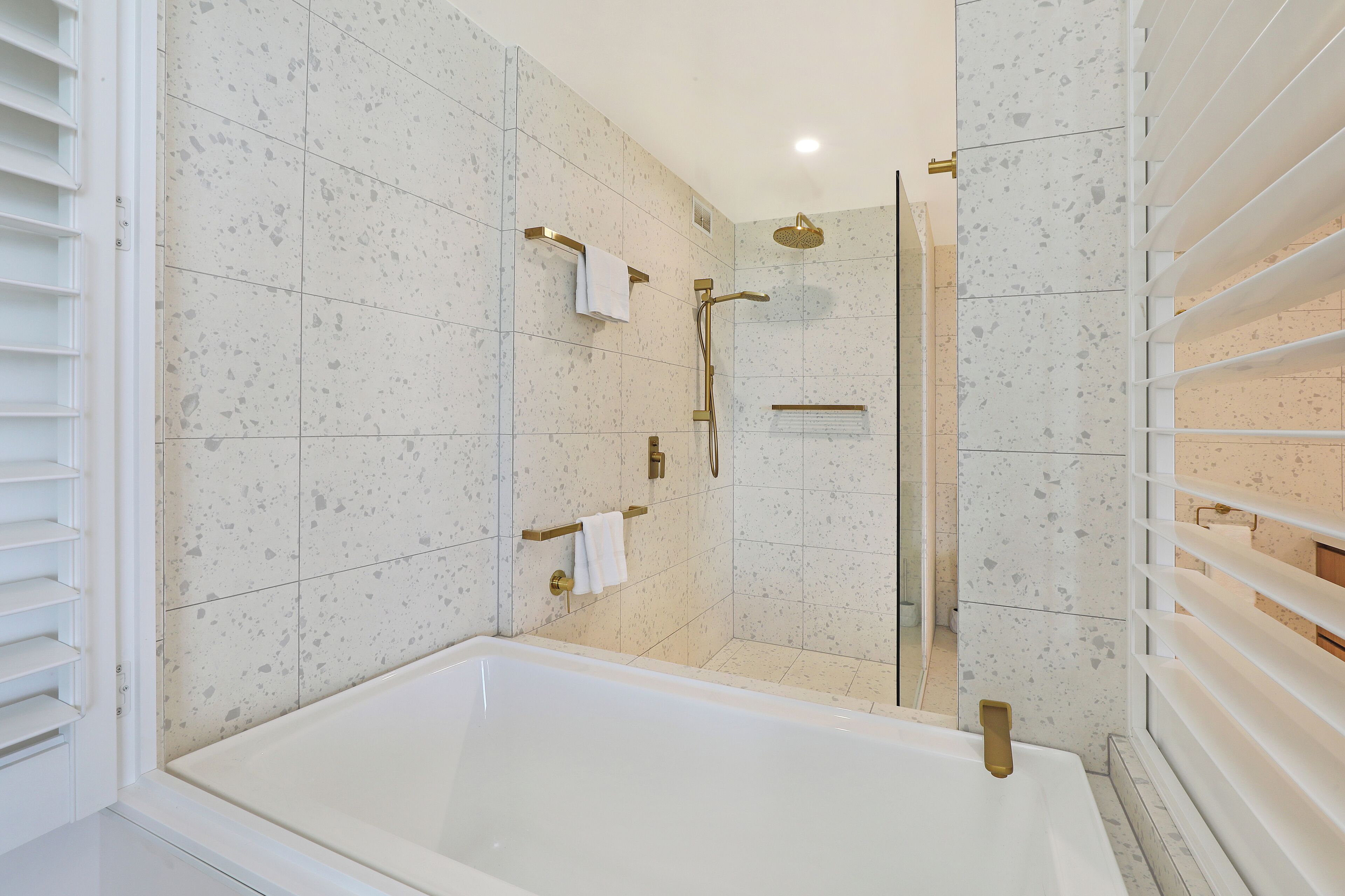 A modern bathroom with a freestanding bathtub, a glass-enclosed shower area, and a towel rack.