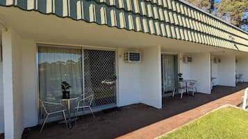 A motel with a covered patio, sliding glass doors, and numbered rooms.