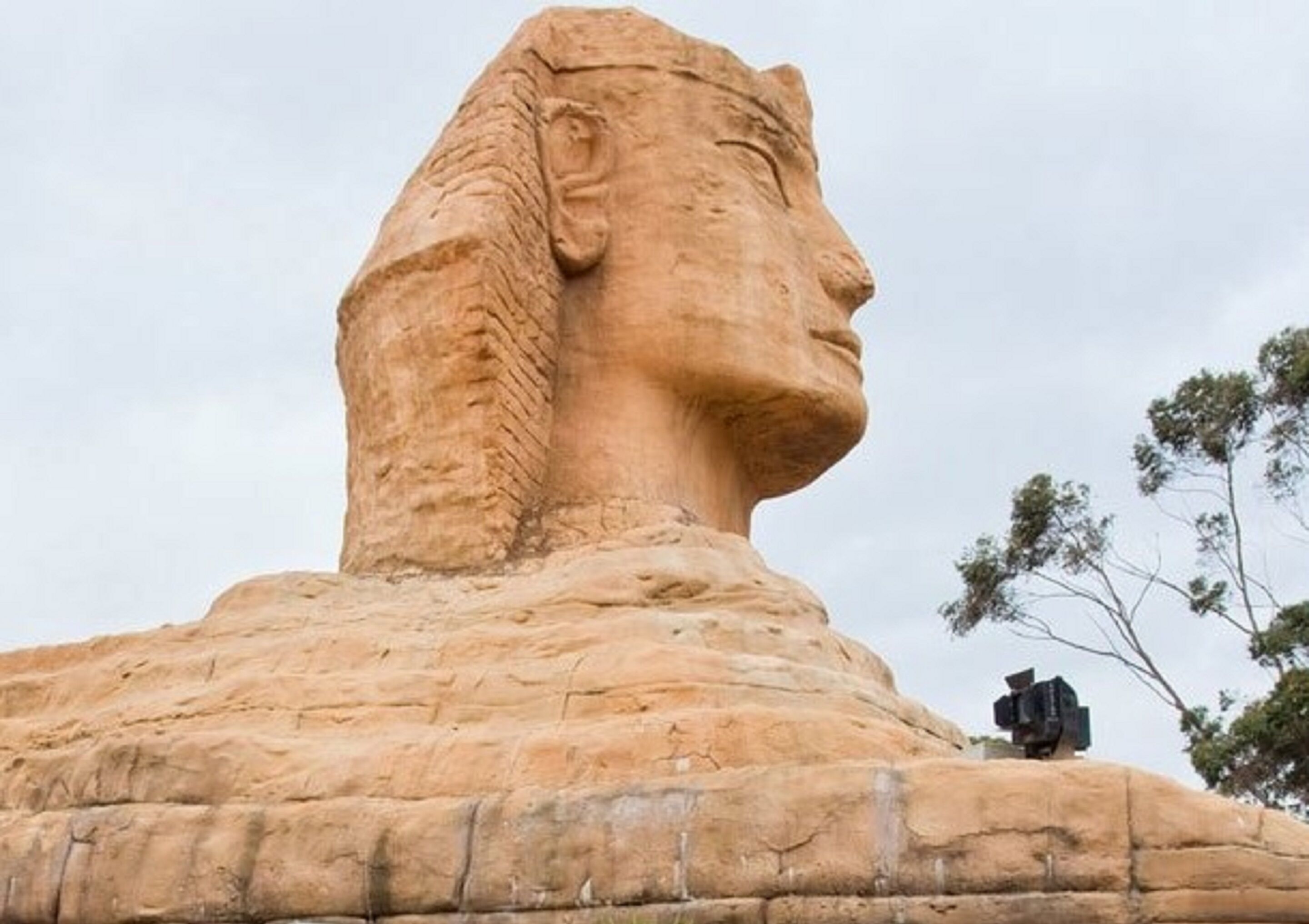 A large stone statue with a smooth surface and a prominent head.
