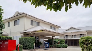 A hotel with a covered entrance, reception area, and a parking lot.