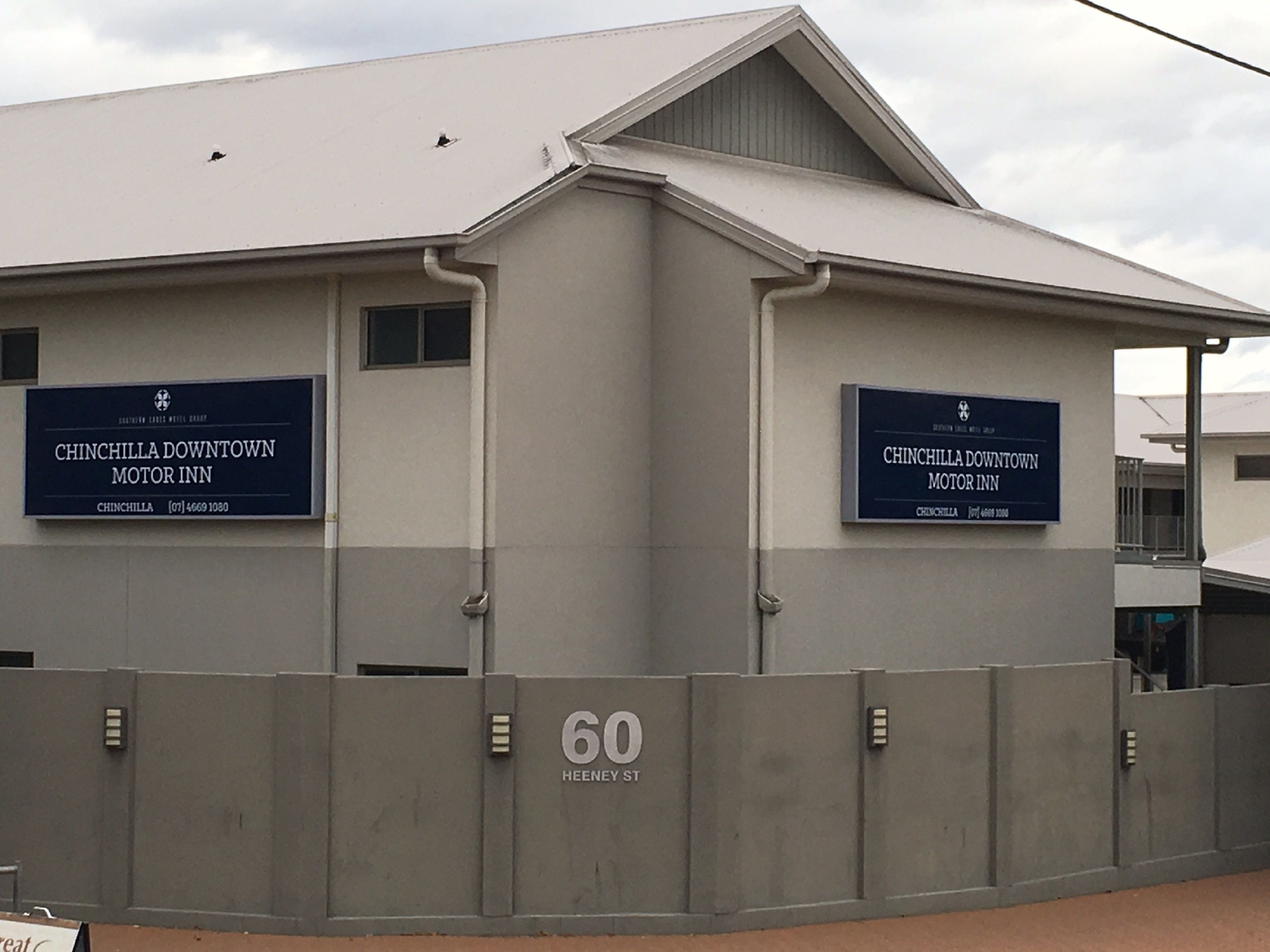 A building with two signs reading "Chinchilla Downtown Motor Inn" and a number "60" on the wall.