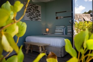 Ein Schlafzimmer mit einem Bett, Nachttisch, Lampe und Kissen.