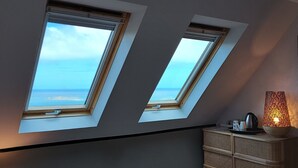 Habitació amb dos finestrals que donen vistes al mar.