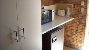 A kitchen with a microwave, toaster, and coffee maker on a countertop.