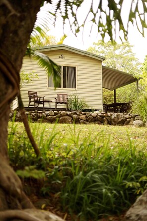 A small, single-story house with a covered patio area. - Mt Warning Rainforest Park (Mount Warning)