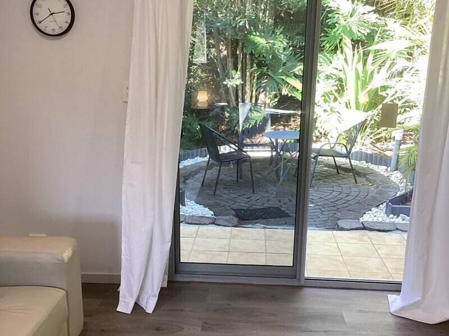 Una habitación con puerta corrediza de vidrio que da a un patio al aire libre.