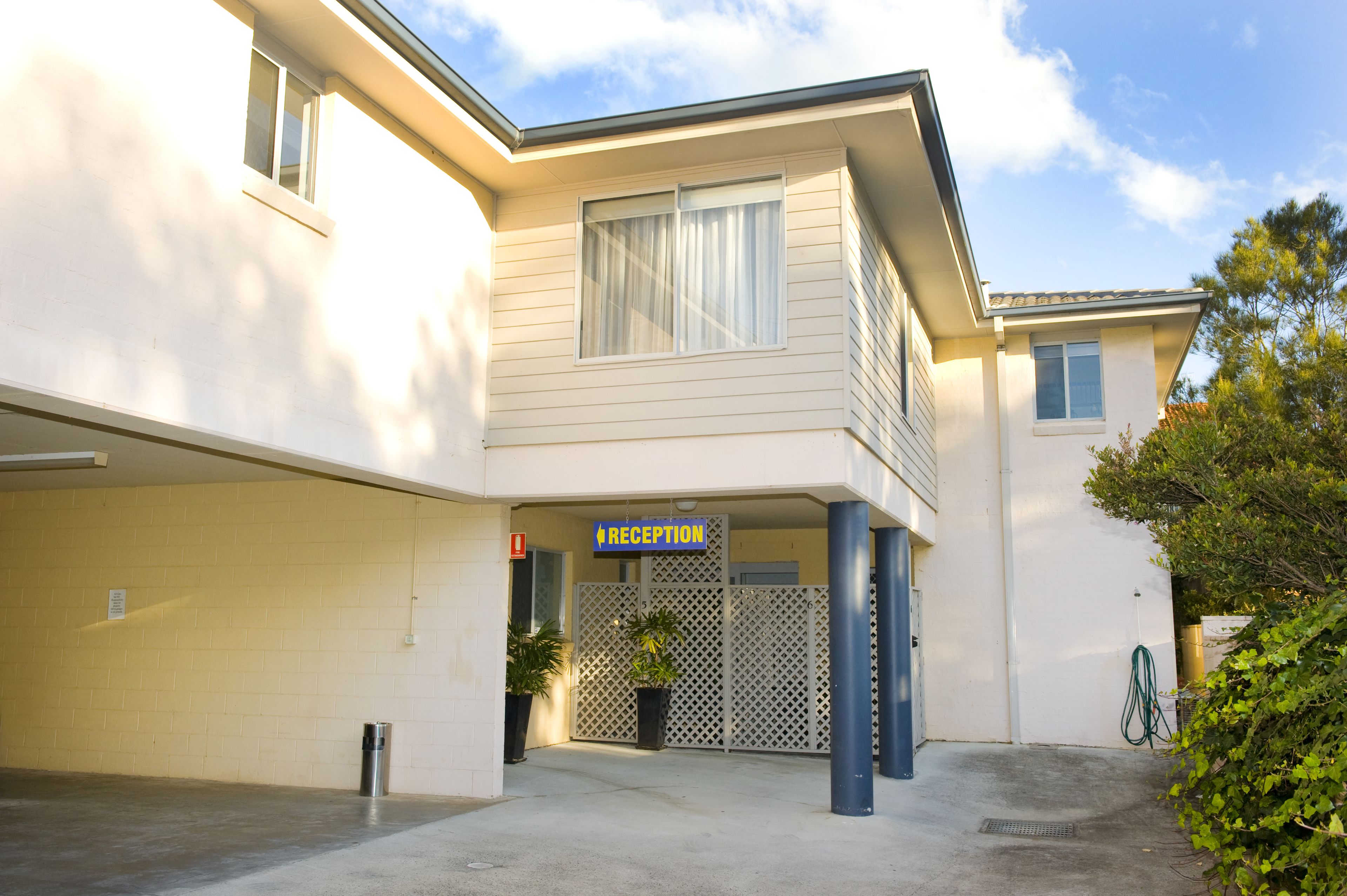 A two-story building with a reception area, a gated entrance, and a parking garage.
