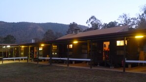 Un chalet rustique doté d’un patio couvert et d’un grand espace extérieur.
