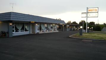 A motel with a single-story structure, a covered parking area, and a sign indicating the presence of a wireless internet facility.