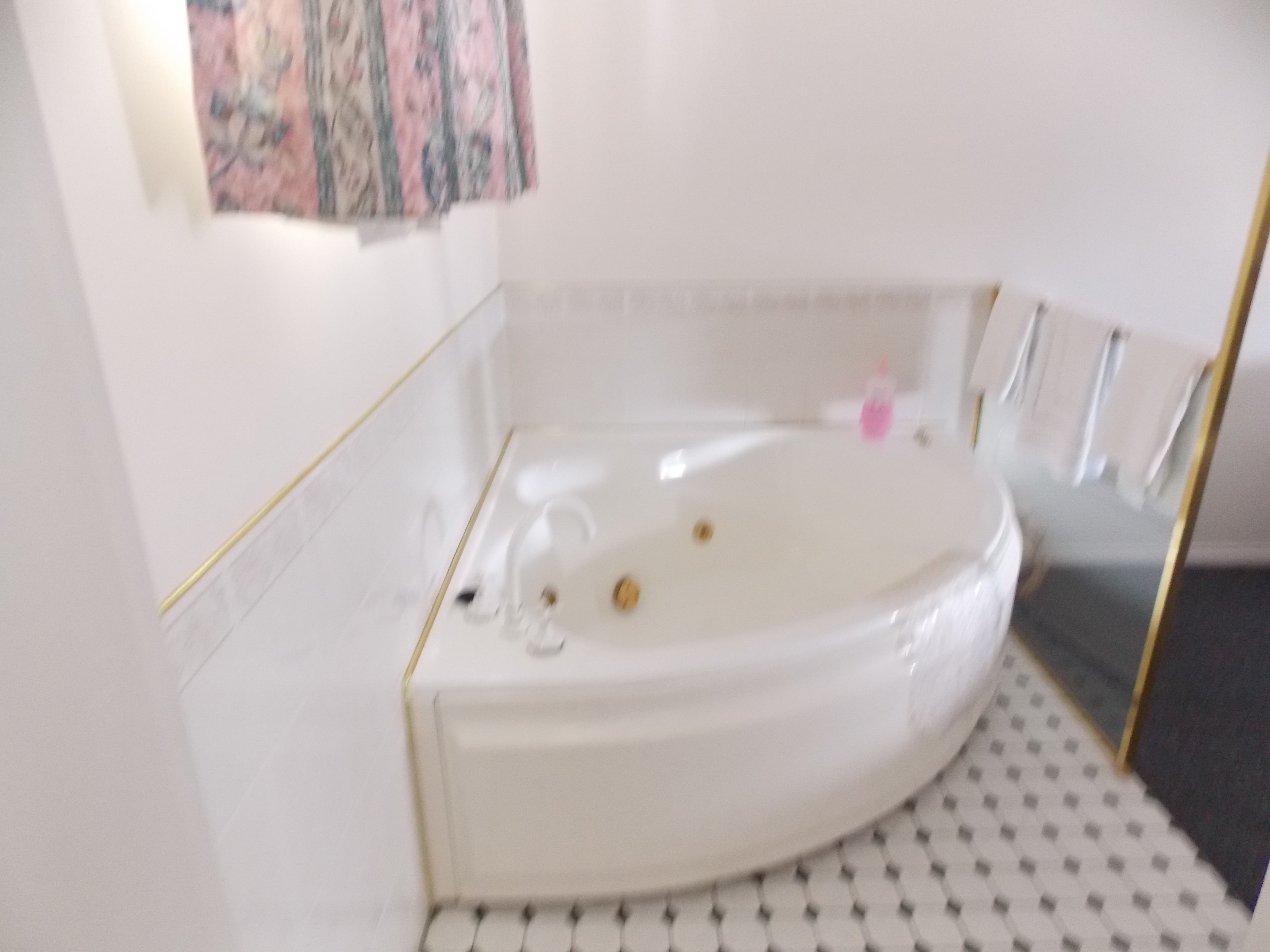 Une salle de bain avec une baignoire blanche, un petit lavabo et des toilettes.