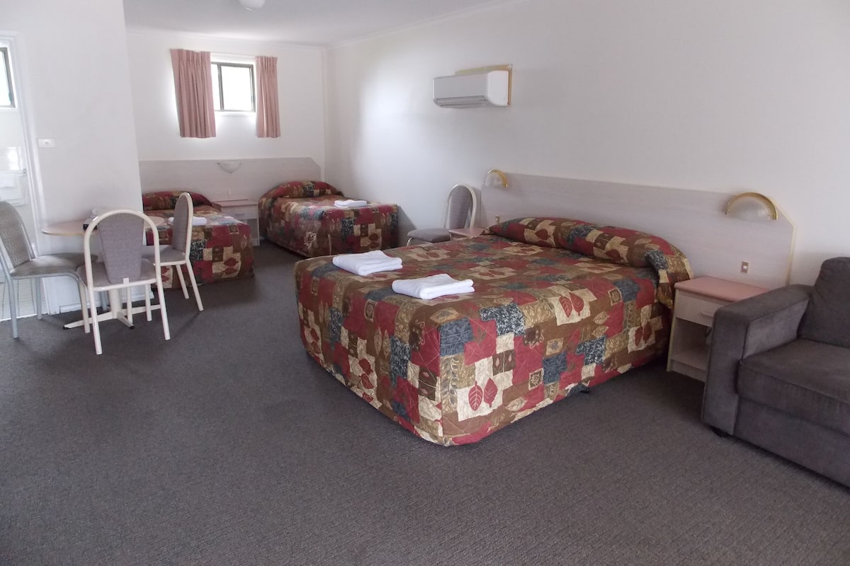 Una habitación de hotel con dos camas, un escritorio y una silla.