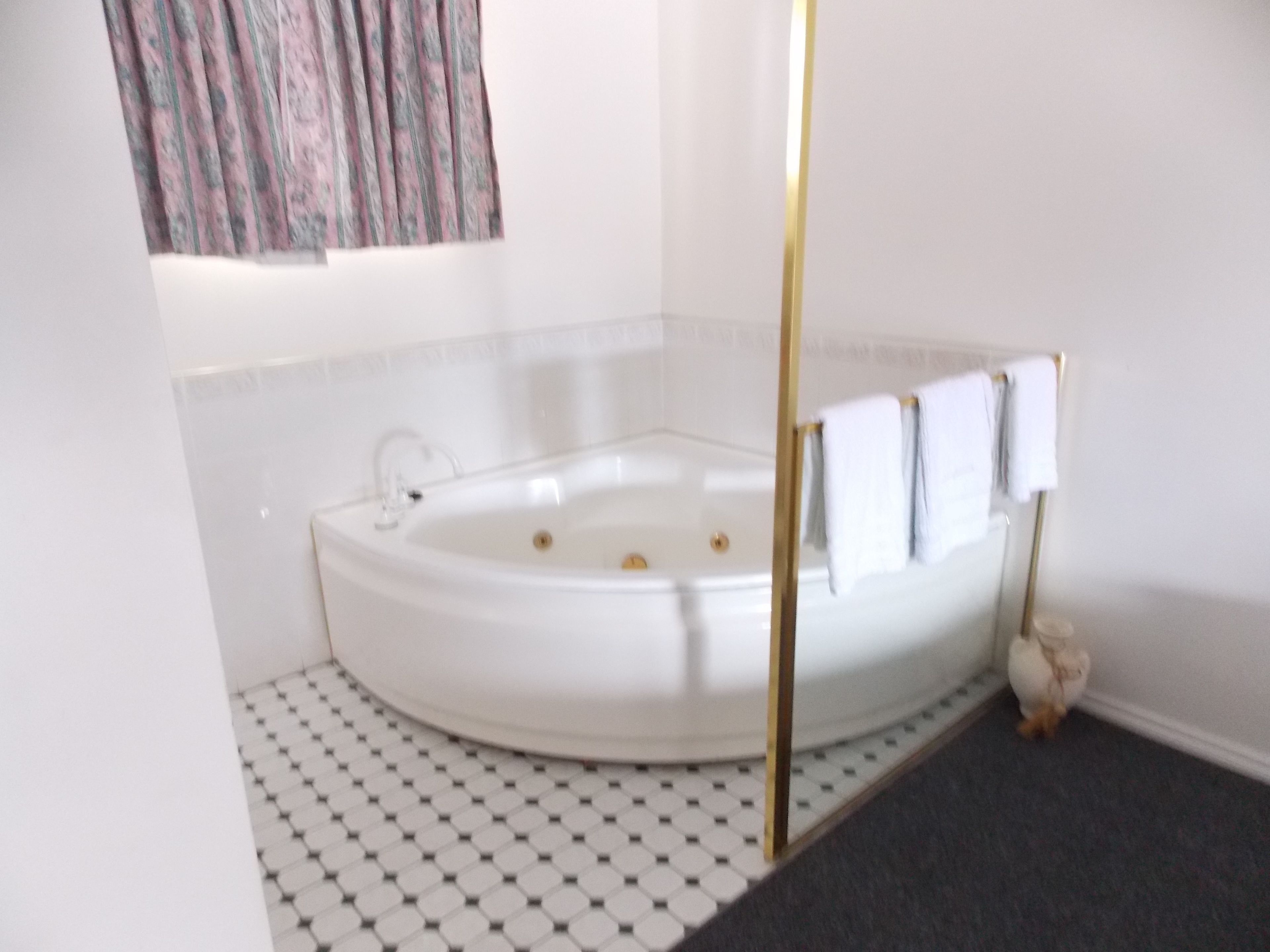 Un baño moderno con una bañera independiente, un lavamanos pequeño y un inodoro.