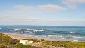 Un paisaje costero con playa, océano y colinas.