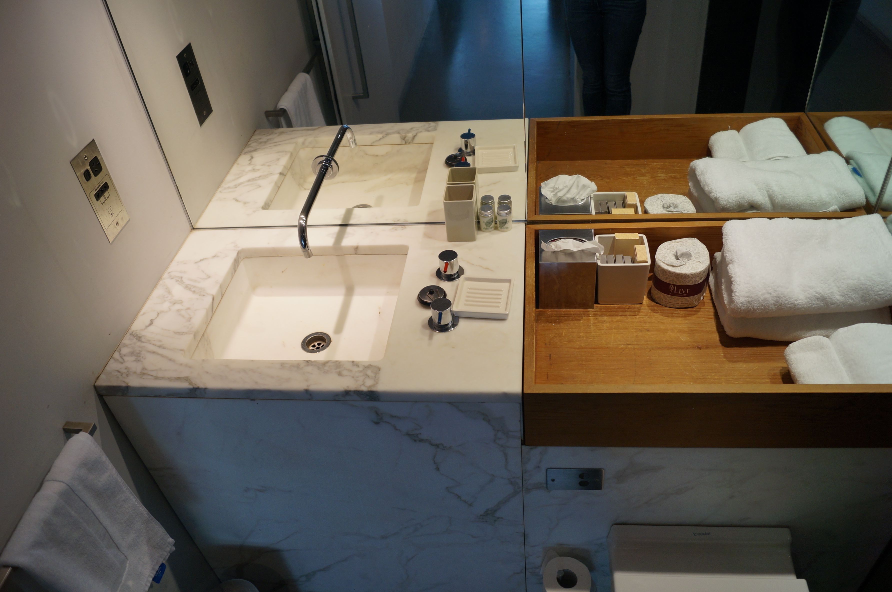 A bathroom with two sinks, a mirror, and a wooden vanity with towels.