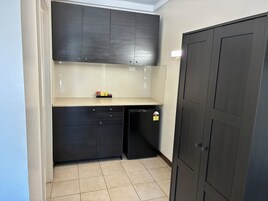 A compact kitchen with dark cabinetry, a small countertop, and a dishwasher.