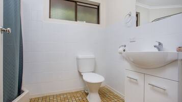 Un bagno con il water, lavandino e pavimento piastrellato.
