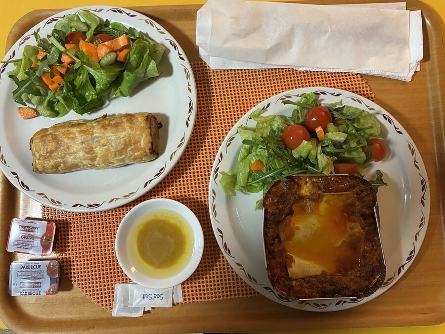 Twee borden eten, een servet en kruiden op een dienblad.