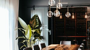 Een moderne eetruimte met een houten tafel, stoelen en een hanglamp.