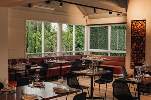 A restaurant with a modern interior, featuring a mix of seating options including tables and a long bench. - Crittenden Lakeside Villas (Dromana)