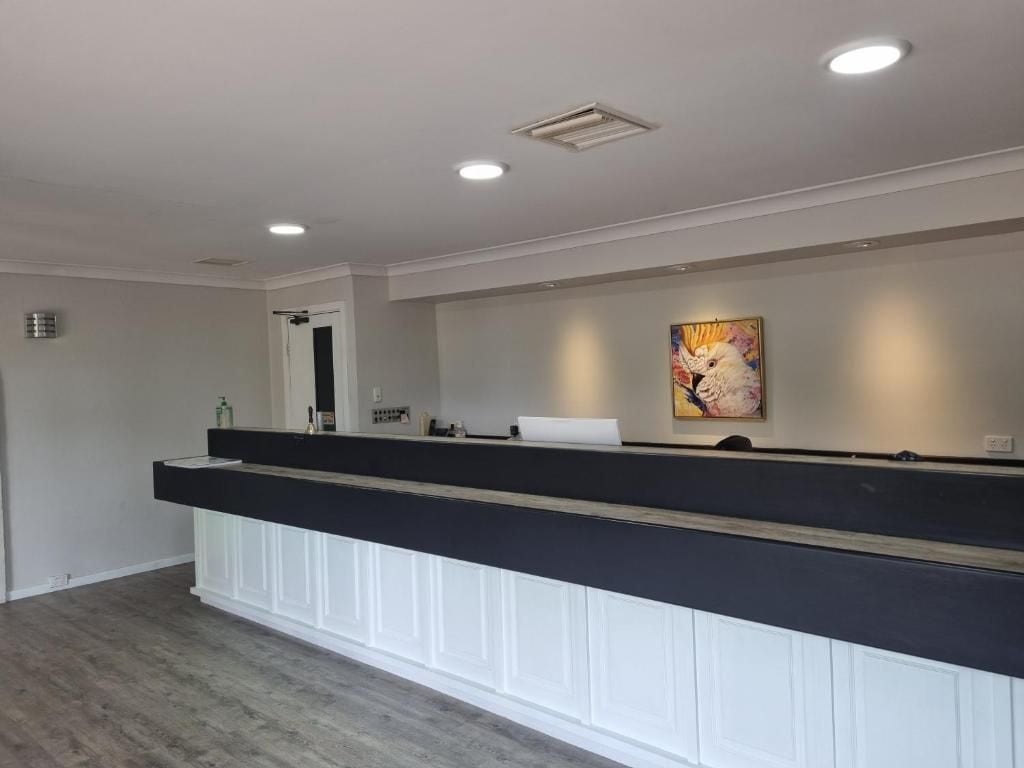 A reception area with a counter, a painting, and a door.