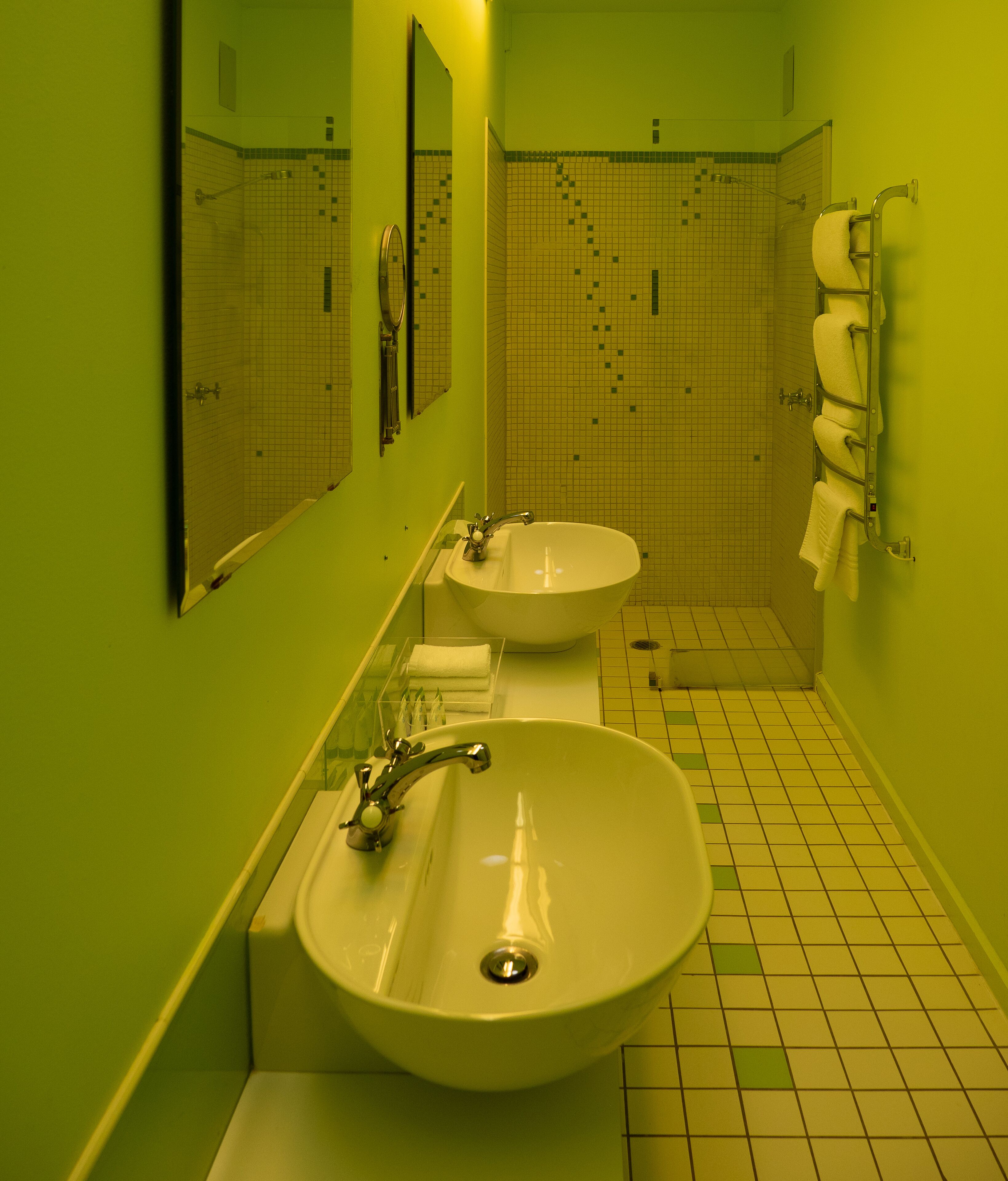 A bathroom with two sinks, a mirror, and a towel rack.