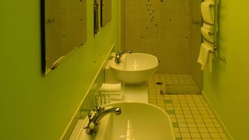 A bathroom with two sinks, a mirror, and a towel rack.