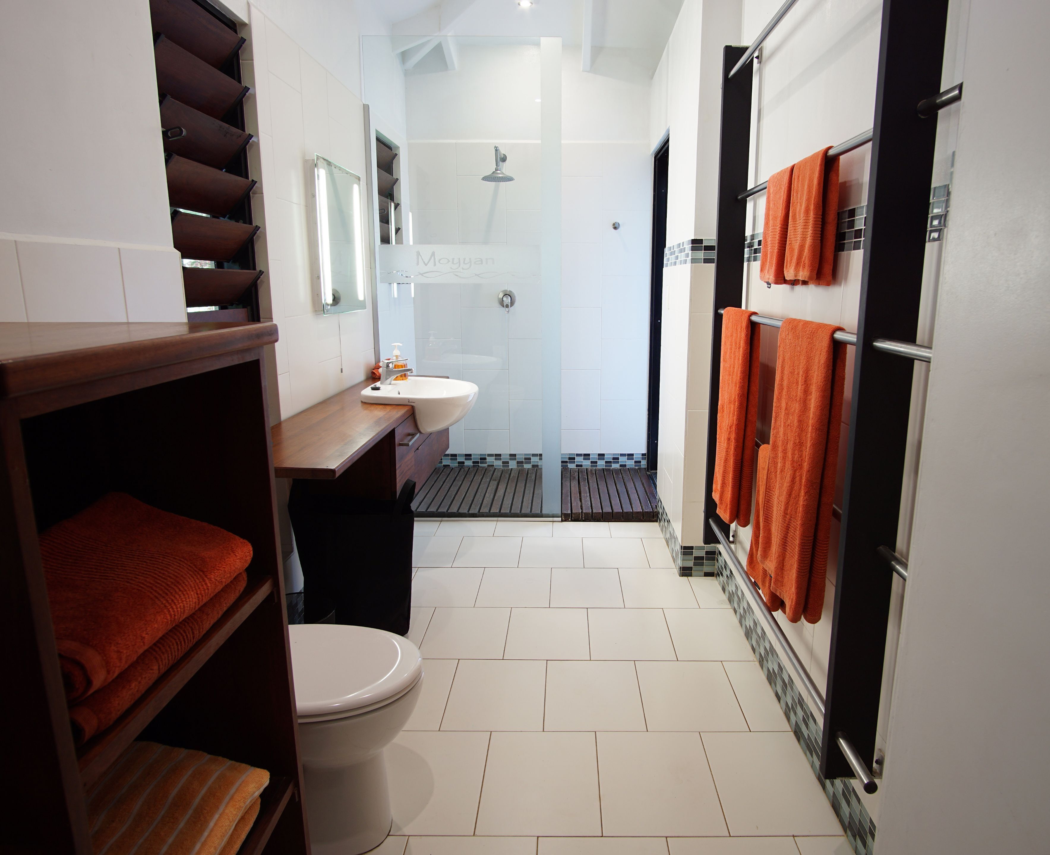 A modern bathroom with a toilet, sink, and shower area.