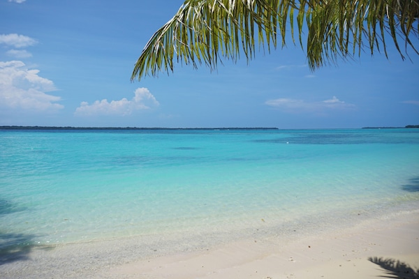 On the beach, white sand, sun loungers, beach towels