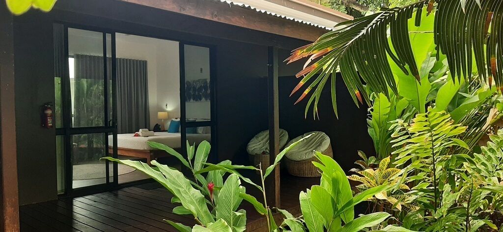 Una habitación con una cama, una ventana y una puerta que da a un balcón.