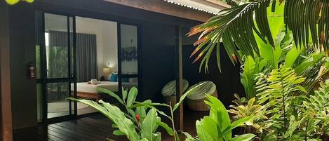 Una habitación con una cama, una ventana y una puerta que da a un balcón.